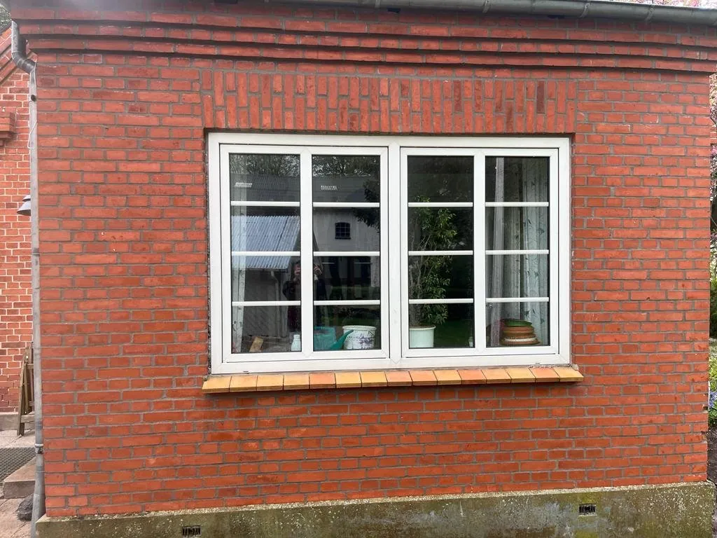Facade i røde mursten med hvide vinduer